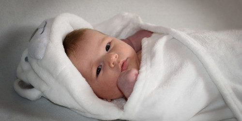 Baby - in weisse Decke eingewickelt